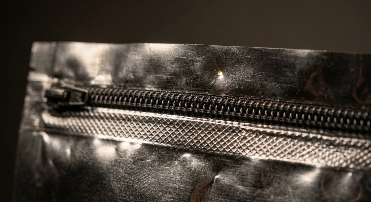 Macro view of pouch heat seal and zipper track with pinhole defect